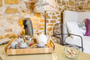 una mesa con una bandeja con una cafetera y una lámpara en Les Terrasses Dorées - Chambres d'hôtes de charme & Jacuzzi, en Châtillon