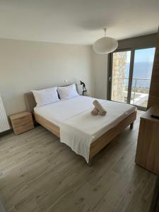 a bedroom with a large bed and a large window at Villa Buddha in Syvota