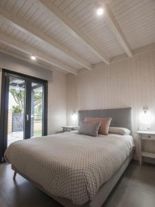 a bedroom with a large bed and a large window at Casas Guemon in Zahora