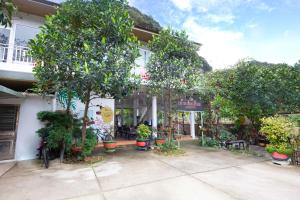 a building with trees and plants in front of it at Cat Ba Countryside Homestay in Cat Ba