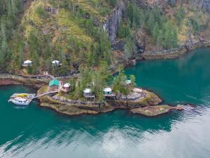 an island with houses and a boat in the water at Orca Island Cabins in Seward