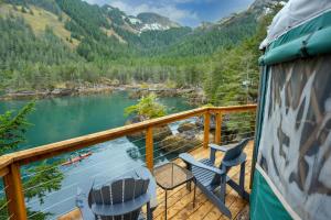 a deck with chairs and a view of a river at Orca Island Cabins in Seward