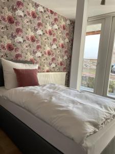 Schlafzimmer mit einem Bett mit Blumentapete in der Unterkunft Das Haus zur Rothen Thür 2 in Arnstadt