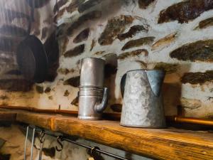 two metal containers sitting on a wooden shelf at il Bosco in Roccaforte Mondovì