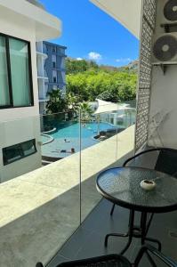 a balcony with a table and a swimming pool at Utopia - the best condo project at Naiharn in Rawai Beach