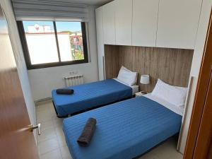 a hotel room with two beds and a window at Ático en Cubelles playa in Cubelles