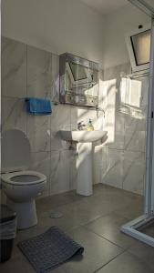 bagno con lavandino, servizi igienici e specchio di Banana Tree House a Ponta do Sol