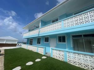 un edificio blu e bianco con un prato di Nautilus Ocean Suites a Bridgetown