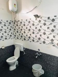 a bathroom with a toilet and a black and white wallpaper at ECO VILLA in Puducherry