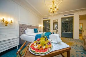 a hotel room with a tray of fruit on a table at Grand Hotel Belushi in Boge