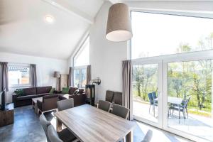 a living room with a table and a large window at House and Apt. in Mistelgau-Obernsees 26603 in Obernsees