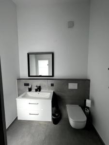 a bathroom with a white sink and a toilet at Ferienwohnung Lorenz in Olching