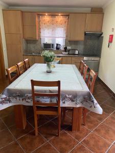 una cocina con una mesa con un jarrón de flores. en Casa de Pichoses, en Gerês