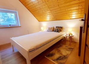にあるCałoroczny domek nad Jeziorem Piasecznoの木製の天井のベッドルーム1室(大型ベッド1台付)