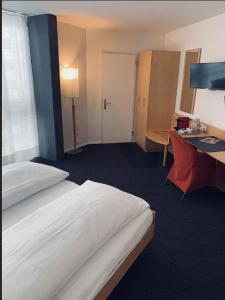 a hotel room with a bed and a desk and a bedroom at Work Life Residence by Frauenfeld in Frauenfeld