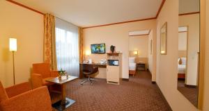 a hotel room with a desk and a room at Sure Hotel by Best Western Hilden-Düsseldorf in Hilden