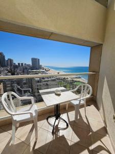a balcony with a table and two chairs and a large window at GO to apartments in Leonardo in Bat Yam