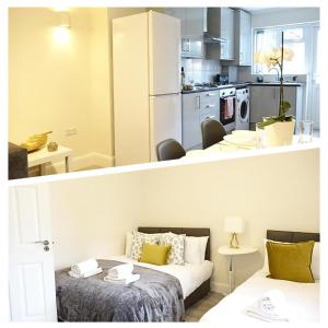 2 Bilder von einer Küche und einem Wohnzimmer mit einem Bett in der Unterkunft The Close Airport in Harmondsworth