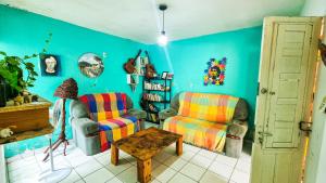 ein Wohnzimmer mit 2 Stühlen und einem Tisch in der Unterkunft Proxima Estacion Hostel in Maceió