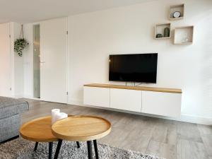 a living room with a television on a white cabinet at Bungalow 57 op Recreatiepark De Wielen in Sint Maarten