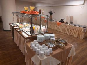 una línea de buffet con platos blancos y comida en Hotel Financial en Belo Horizonte