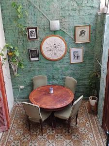 a wooden table with chairs and a clock on a wall at La Risa de la Medusa in Buenos Aires