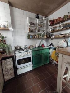 cocina con armarios verdes y estufa blanca en La Risa de la Medusa en Buenos Aires