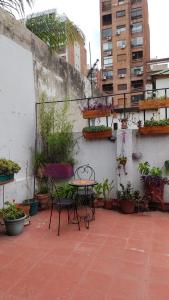 un patio con mesa, sillas y macetas en La Risa de la Medusa en Buenos Aires