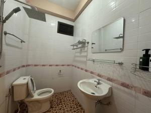 een badkamer met een toilet en een wastafel bij Champa Inn Hotel in Vang Vieng