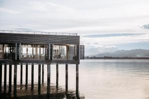 una casa en un muelle sobre un cuerpo de agua en Seehotel am Kaiserstrand en Lochau