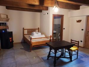 Un dormitorio con una cama y una mesa. en Villaggio Borgomaira La Ginestra 