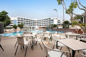 un patio con mesas y sillas frente a un hotel en Peggy´s Home, en San Miguel de Abona