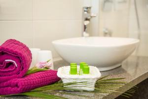 eine Badezimmertheke mit einem rosa Handtuch und einem Waschbecken in der Unterkunft Gästehaus Stock Hotel und Ferienwohnungen in Friedrichshafen
