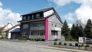 ein rosa und schwarzes Gebäude an der Straßenseite in der Unterkunft Hotel Gästehaus Stock in Friedrichshafen