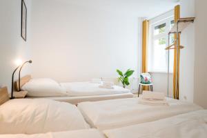due letti bianchi in una stanza con una finestra di Spacious 3BR plus AC Self Check-in Street Parking a Berlino