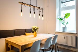 una sala da pranzo con tavolo e sedie in legno di Spacious 3BR plus AC Self Check-in Street Parking a Berlino