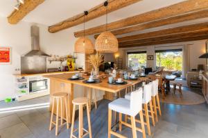 een keuken met een groot houten eiland met barkrukken bij Santal : maison avec piscine entre terre et mer in Saint-Pargoire
