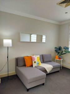 sala de estar con sofá gris y almohadas coloridas en Perfect and modern apartment Broadway-Chippendale, en Sídney
