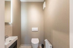 フーズムにあるFerienwohnung Hafen-Zeit direkt am Husumer Hafenの白いトイレと洗面台のあるバスルーム
