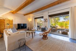 een woonkamer met een bank en een tv bij Santal : maison avec piscine entre terre et mer in Saint-Pargoire