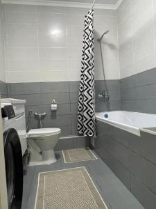 La salle de bains est pourvue de toilettes, d'une baignoire et d'un lavabo. dans l'établissement Comfort 2 ЖК Lake town, à Almaty