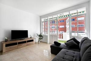 a living room with a couch and a flat screen tv at Atlantic Blue Dream Caletillas in Araya