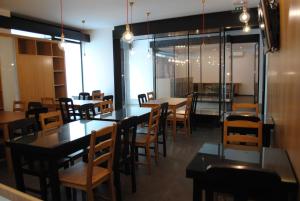 a dining room with tables and chairs and windows at Moderna in Coimbra
