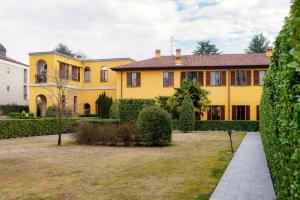 una vista exterior de una casa amarilla con patio en Medel - by MyHomeInComo, en Appiano Gentile