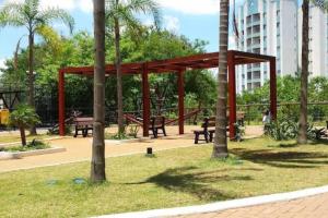 a pavilion with picnic tables and palm trees in a park at Aeroporto de Guarulhos 1 in Guarulhos