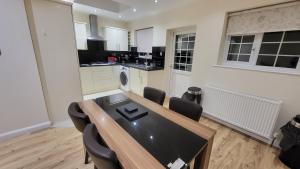 a kitchen with a table and chairs in a room at Garland Modern Spacious Apartment With Garden in Edgware