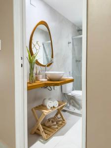 a bathroom with a sink and a mirror at Casa Sol Ipioca in Maceió
