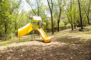 un parque infantil con toboganes amarillos en Posada Alma del Arroyo & Spa en Villa General Belgrano