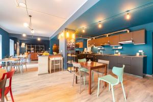 a dining room and kitchen with tables and chairs at Ostello Bello Genova in Genoa