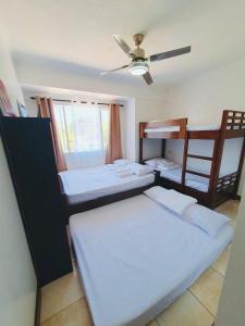 a room with two beds and a ceiling fan at BAGUIO ALBERGO HOTEL CONDO TRANSIENT by DEI GRATIA in Baguio